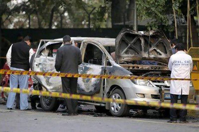 Indian security and forensic officials examine a car belonging to the Israel embassy after an explosion in New Delhi.