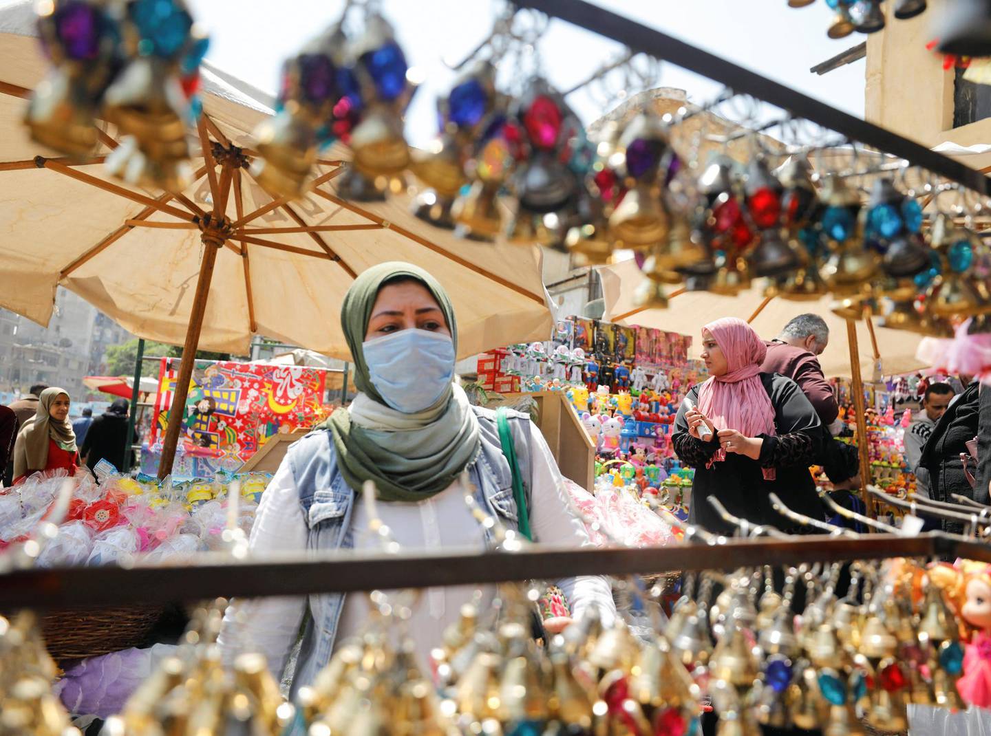 A woman wearing a protective face  mask, amid concerns over the coronavirus disease (COVID-19) buys traditional Ramadan lanterns, called "Fanous" which are displayed for sale at a stall, ahead of the Muslim holy month of Ramadan in Cairo, Egypt, April 12, 2020. REUTERS/Mohamed Abd El Ghany