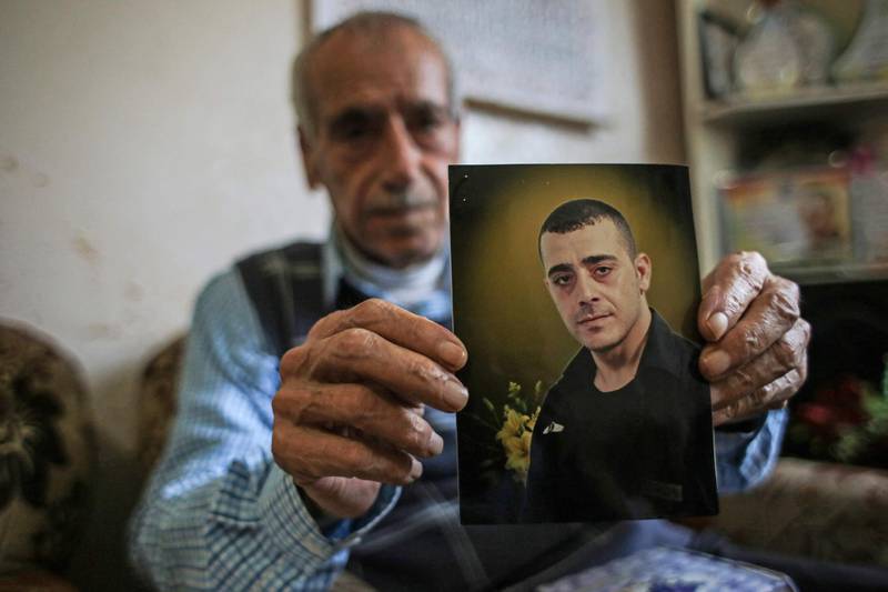 Palestinian Samih Qaadan holds a picture of his son Abdulrauf, who has been held in an Israeli prison since 2004.  AFP
