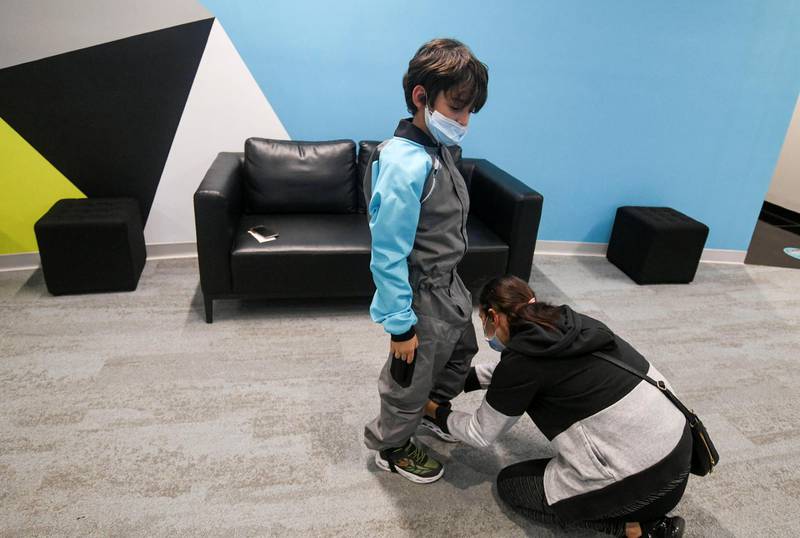 Abu Dhabi, United Arab Emirates - Mazen, 7, having his suit adjusted by his mother, Samia before his indoor skydiving adventure at CLYMB, Yas Island. Khushnum Bhandari for The National