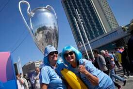 Supporters of Manchester City gather near a giant Champions League trophy shaped balloon, on the background, at Taksim square in Istanbul, Turkey, Saturday, June 10, 2023, ahead of the Champions League final soccer match between Manchester City and Inter Milan.  (AP Photo / Khalil Hamra)