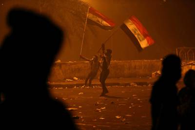 Demonstrators hold Iraqi flags during a protest over corruption, lack of jobs, and poor services, in Baghdad, Iraq. Reuters