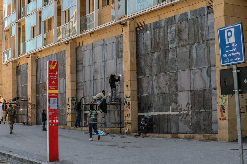 Workers fix iron shields on the storefronts to protect them from cracking during riots during upcoming demonstrations in downtown Beirut, Lebanon.  EPA