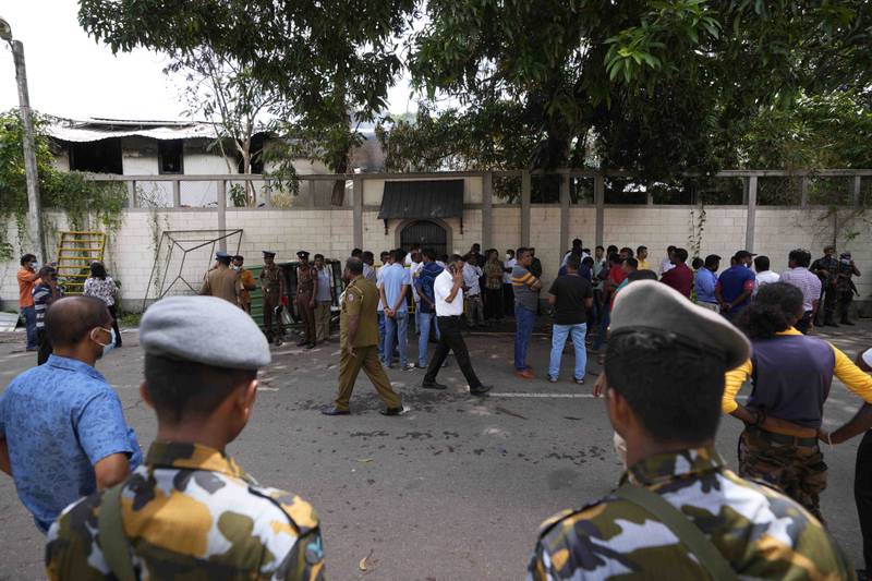 Soldiers and police gather outside the burnt private residence of Prime Minister Ranil Wickremesinghe in Colombo. AP