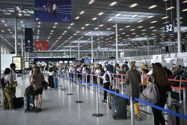 Travellers, wearing protective face masks, line up at Orly Airport during a major weekend of the French summer holidays in August. The International Air Transport Association is working on a mobile app to show travellers are free of Covid-19. AFP 