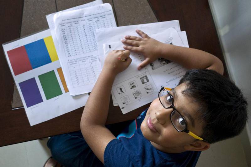 Nine-year-old Ayaan Khan, who is left-handed, works on his Arabic studies homework in Abu Dhabi in 2016. Delores Johnson / The National