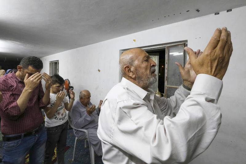 Members of the Ashour family gather in prayer at a family home, due to closure of mosques during the coronavirus pandemic, in the flashpoint city of Hebron in the occupied West Bank to mark Lailat al-Qadr, a night in the holy month of Ramadan during which the Koran was first revealed to the Prophet Mohammed in the seventh century.   AFP