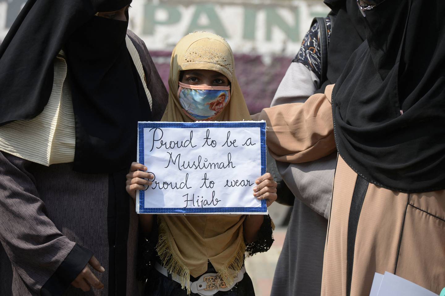 A young girl holds a placard during a silent protest by the Muslim Women Association after female students and pupils wearing the hijab were turned away by some colleges and schools in Hyderabad. AFP