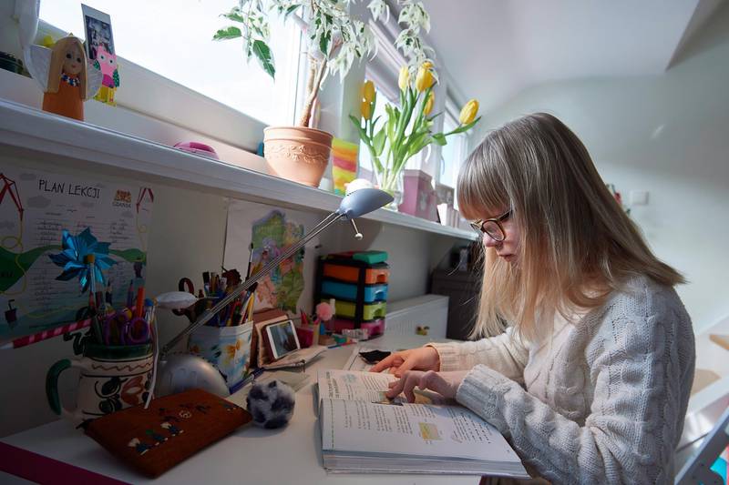 A girl in primary school does her homework, which was received on a digital portal, in her home in Gdansk, Poland, on March 17, 2020. EPA