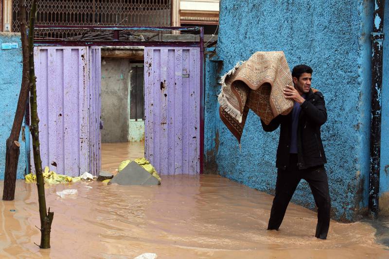 An Iranian man carries a carpet from his flooded home in the city of Khorramabad, Lorestan Province, western Iran. EPA