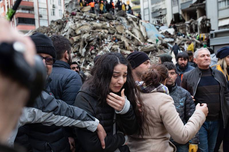 Residents of Turkish city Adana gather at the scene of a collapsed building. The death toll in Turkey and Syria has risen to more than 2,000 after the region's strongest quake in nearly a century.  AFP
