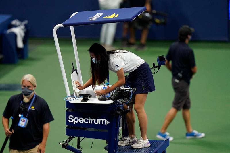 A woman cleans the chair umpire's seat before Naomi Osaka, of Japan, faces Misaki Doi, of Japan. AP Photo