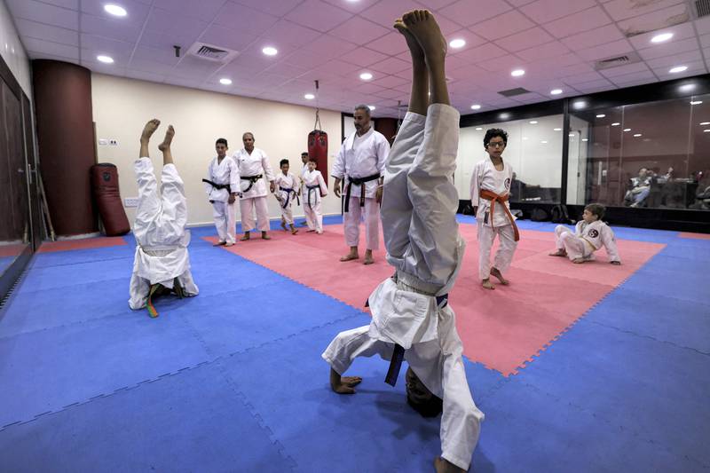 Karate students practise headstands.