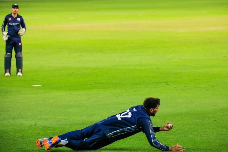 Hamza Tahir makes a diving catch for Scotland against Oman. Photo: ICC