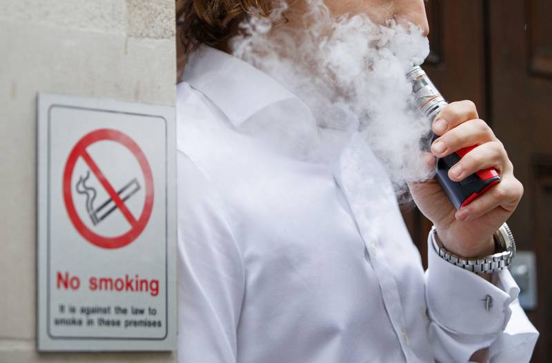A smoker is engulfed by vapours as he smokes an electronic vaping machine during lunch time in central London on August 9, 2017.
World stock markets and the dollar slid Wednesday after US President Donald Trump warned of "fire and fury" in retaliation to North Korea's nuclear ambitions, sending traders fleeing to safe-haven investments. In Europe, equities dived with London losing 0.6 percent, while Frankfurt shed 1.1 percent and Paris fell 1.4 percent. / AFP PHOTO / Tolga Akmen