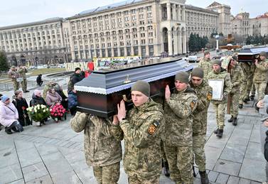Ukrainian servicemen carry the coffins with the bodies of Ukrainian servicemen Oleg Khomyuk, 52, and his 25-year-old son Mykyta, killed in combat in Bakhmut, during a funeral ceremony at Independence Square in Kyiv on March 10, 2023, amid the Russian invasion of Ukraine.  - Mourners gathered in the centre of Kyiv on March 10, 2023, to pay their respects to a father and son killed together in the fierce fighting for Ukraine's eastern city of Bakhmut, a town that has become a symbolic prize in Russia's war on Ukraine and the scene of months of heavy combat.  (Photo by Sergei SUPINSKY  /  AFP)