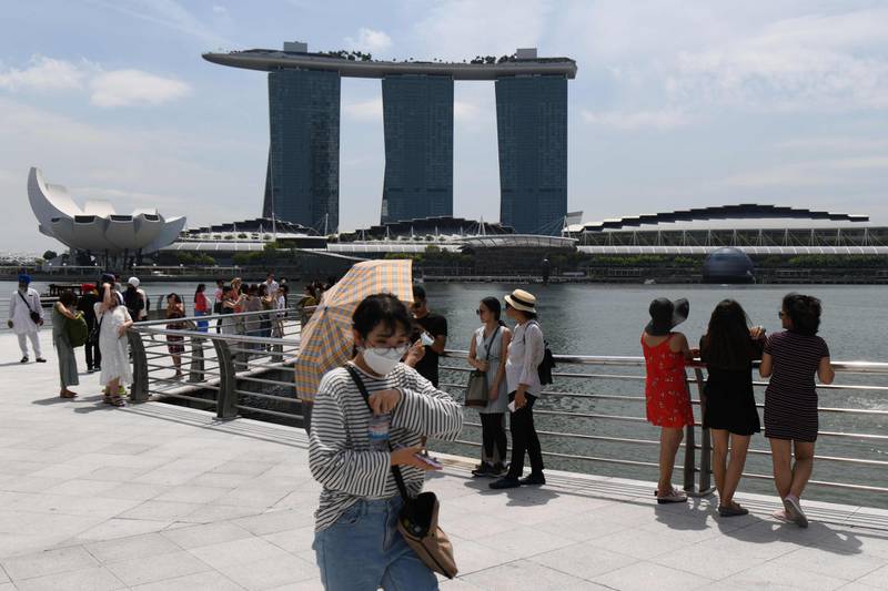 A visitor, wearing a protective facemask amid fears about the spread of the COVID-19 novel coronavirus, walks along Merlion Park in Singapore on February 17, 2020. AFP