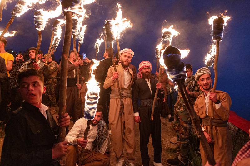 Iraqi Kurds hold torches at the peak of Kali mountain to celebrate Nowruz in Akre. Getty Images