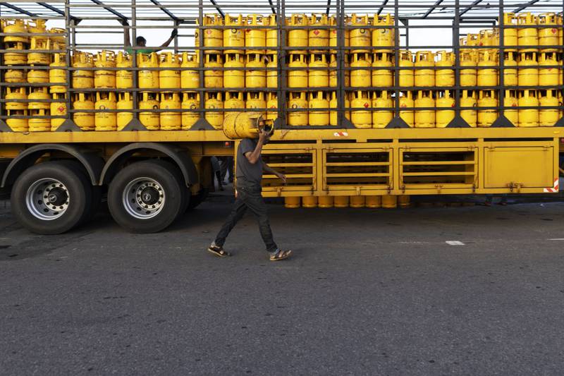 A man carries a cooking gas cylinder in Galle, Sri Lanka. The country has decided to limit distribution of fuel to essential services until July 10. Bloomberg