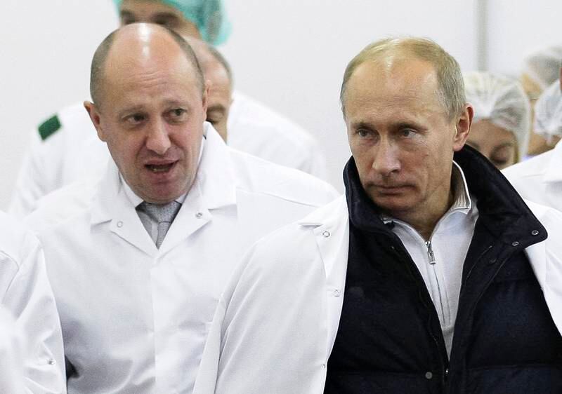 FILE - In this Monday, Sept. 20, 2010 file photo, businessman Yevgeny Prigozhin, left, shows Russian President Vladimir Putin, around his factory which produces school means, outside St. Petersburg, Russia. One of those indicted in the Russia probe is a businessman with ties to Russian President Vladimir Putin. Prigozhin is an entrepreneur from St. Petersburg who's been dubbed "Putin's chef" by Russian media. His restaurants and catering businesses have hosted the Kremlin leader's dinners with foreign dignitaries. (Alexei Druzhinin, Sputnik, Kremlin Pool Photo via AP, File)