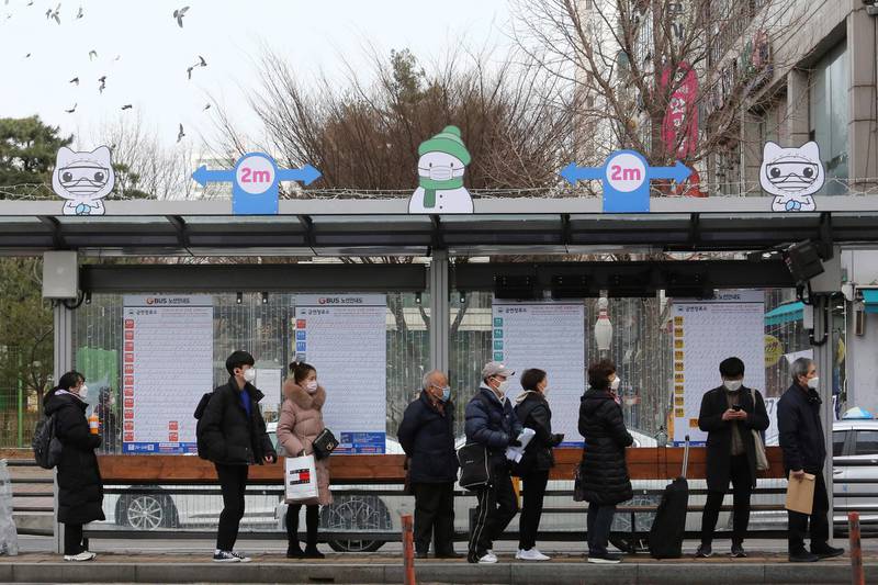 People wearing face masks to help protect against the spread of the coronavirus wait for buses at a bus station in Goyang, South Korea, Wednesday, Jan. 27, 2021. (AP Photo/Ahn Young-joon)