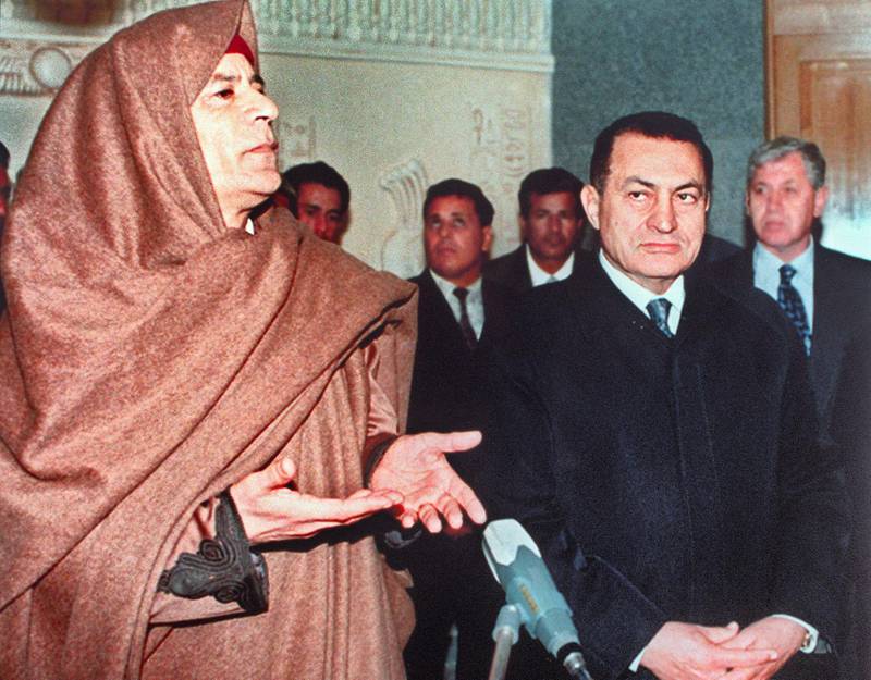 Libyan Head of State Colonel Moamer Kadhafi answers journalists flanked by Egyptian President Hosni Mubarak 18 January 1996 in Sidi Barrani during their first summit meeting since June 1994. Kadhafi, born in 1942, formed in 1963 the Free Officers Movement, a group of revolutionary army officers, which overthrew 01 September 1969 King Mohammed Idris of Libya and proclaimed Libya, in the name of "freedom, socialism and unity," Socialist People's  Jamahiriya. (Photo by AFP)