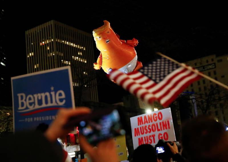 A balloon depicting U.S. President Donald Trump as a baby flies over protest signs in Seattle. Reuters