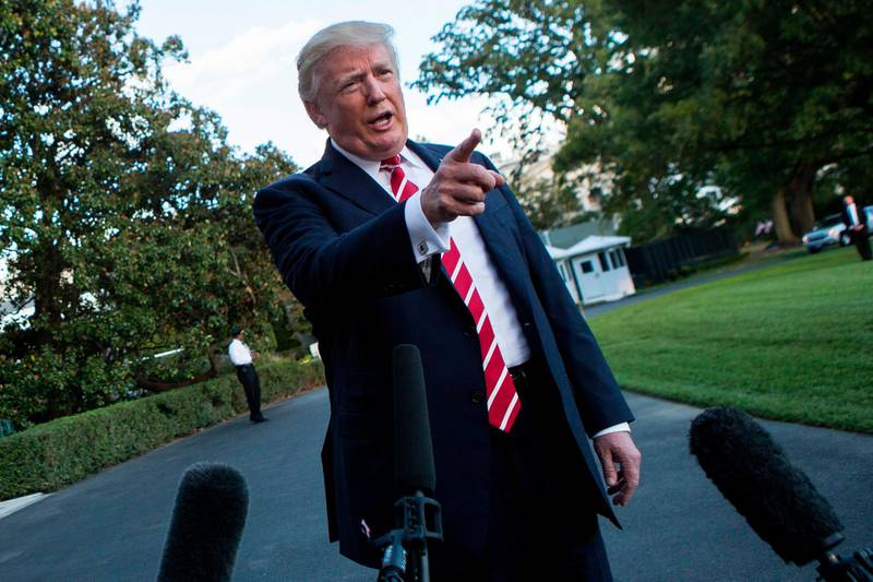 US President Donald Trump speaks with reporters outside the White House prior to his departure aboard Marine One on October 7, 2017. 
During the exchange, President Trump called NBC News, "Fake News" after the news agency reported tension between Trump and US Secretary of State Rex Rex Tillerson. The President will travel to Greensboro, North Carolina this evening to participate in a roundtable discussion with Republican National Committee members. / AFP PHOTO / Alex EDELMAN
