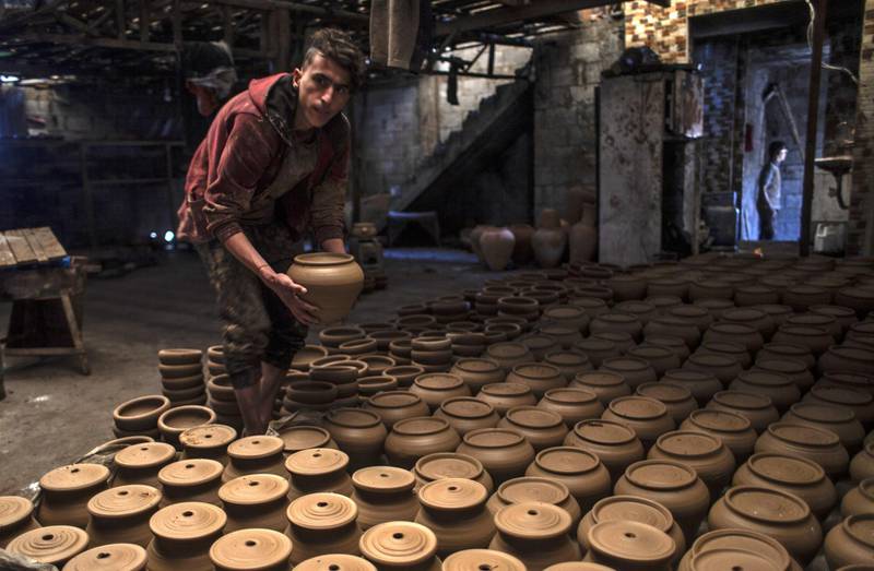 A son of Palestinian potter Sid Atallah lays out pots to dry, at the family workshop in Deir al-Balah in the central Gaza Strip. AFP