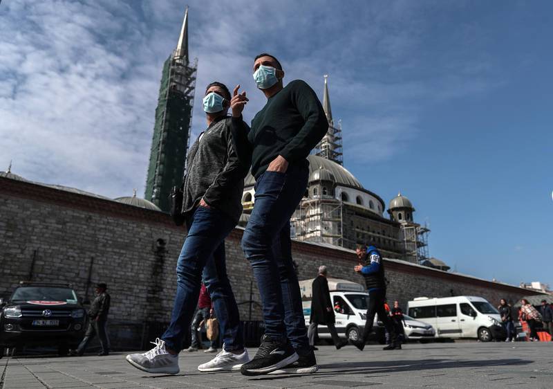 epa08285912 People  wearing a face mask while background seen Taksim Mosque at Taksim Square in Istanbul, Turkey, 11 March 2020. Turkish Health Minister Fahrettin Koca announced the first coronavirus COVID-19 case in Turkey of a male patient who tested positive and was isolated.  EPA/SEDAT SUNA