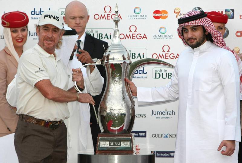 Spain's Miguel Angel Jimenez (L) receives his trophy from Sheikh Ahmed bin Mohammed bin Rashed al-Maktoum (R), son of Dubai ruler Sheikh Mohammed bin Rashed al-Maktoum, after winning the Dubai Desert Classic golf championship in the Gulf emirate on February 7, 2010. Jimenez won the Dubai Desert Classic for the first time, defeating European No.1 Lee Westwood on the third hole of a drama-packed playoff. AFP PHOTO/KARIM SAHIB (Photo by KARIM SAHIB / AFP)