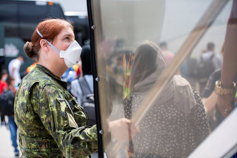 A Canadian Armed Forces medic assists Afghan refugees at Toronto Pearson International Airport. Photo: Canadian Forces Combat Camera/Handout via Reuters