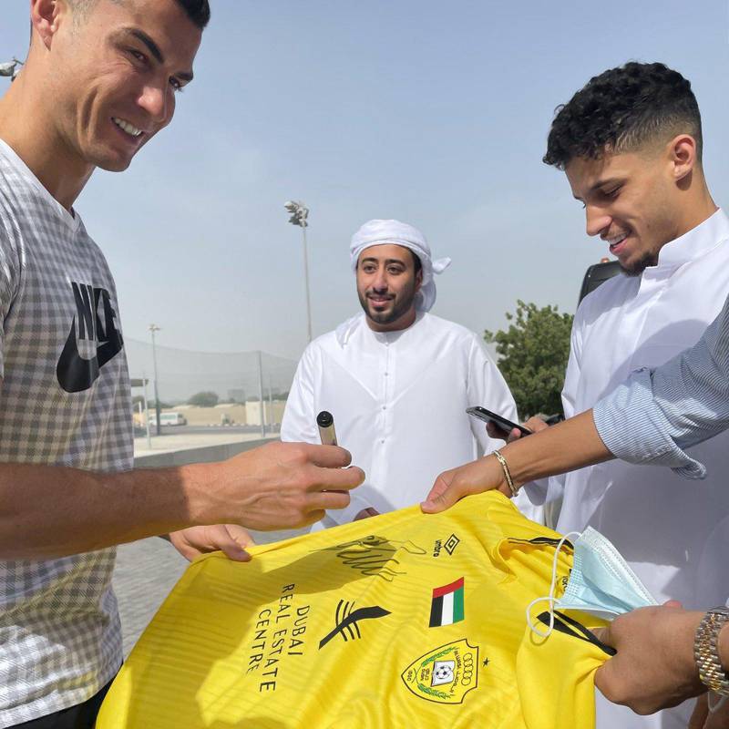 Cristiano Ronaldo, left, signs an Al Wasl shirt with Wasl midfielder Ali Saleh, right. Courtesy Twitter