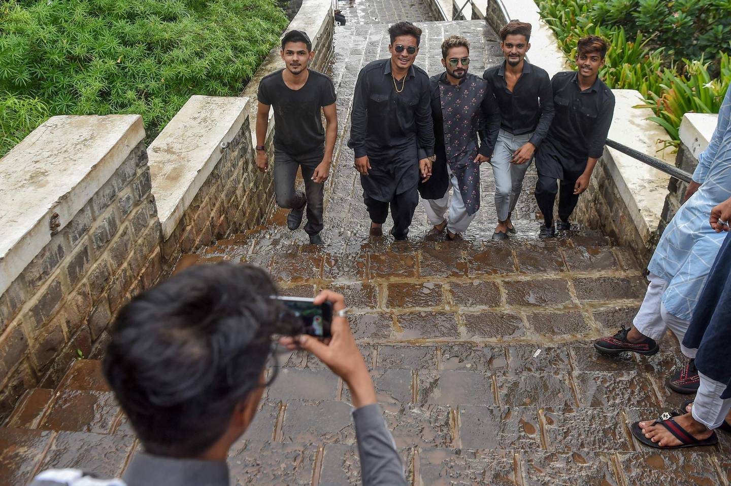 In this photo taken on November 10, 2019, youngsters record a video for the video-sharing app TikTok in Mumbai. He's no Bollywood superstar, but Israil Ansari can barely walk down a street in India without teenagers flocking to him for autographs -- thanks to TikTok, the addictive and controversial app on which he has two million followers. / AFP / Indranil MUKHERJEE / TO GO WITH AFP STORY India-TikTok-video-science-internet,FOCUS by Vishal MANVE
