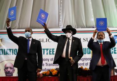 Sudan's Sovereign Council Chief General Abdel Fattah Al Burhan, South Sudan's President Salva Kiir, and Sudan's Prime Minister Abdalla Hamdok raise copies of a signed peace agreement with Sudan's five key rebel groups in Juba, South Sudan on August 31, 2020. Reuters