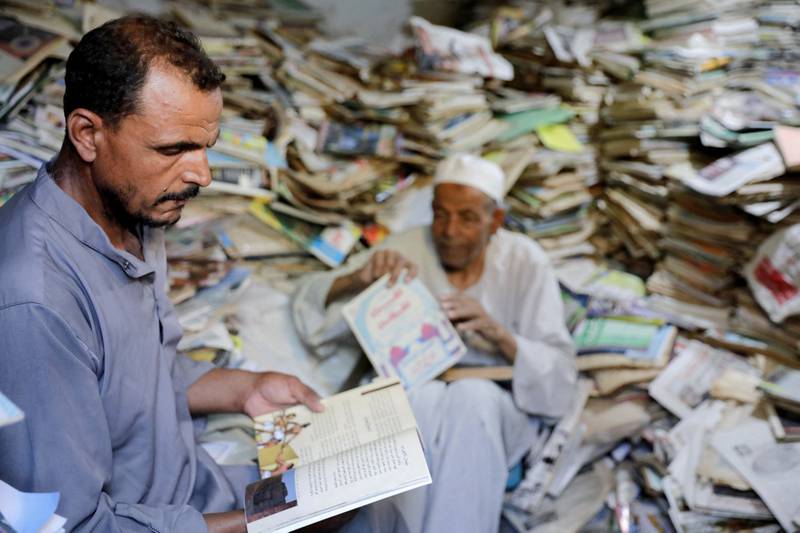 Abdallaa Abu Dawh, 82, (right) a former teacher at Egypt's Al Azhar University who now works as an imam, reads with a man in a library at his basement home which contains some 15,000 books he has collected. In his village in the Nile Delta, Dakahlia governorate, which is north of Cairo, he offers young men and women free books to read. 
