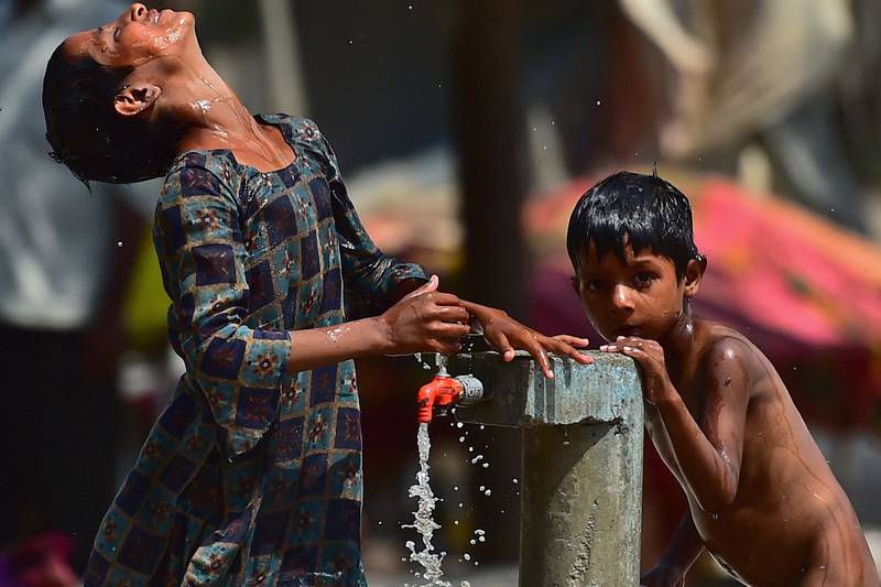 Children use a roadside tap to cool down in Allahabad. AFP