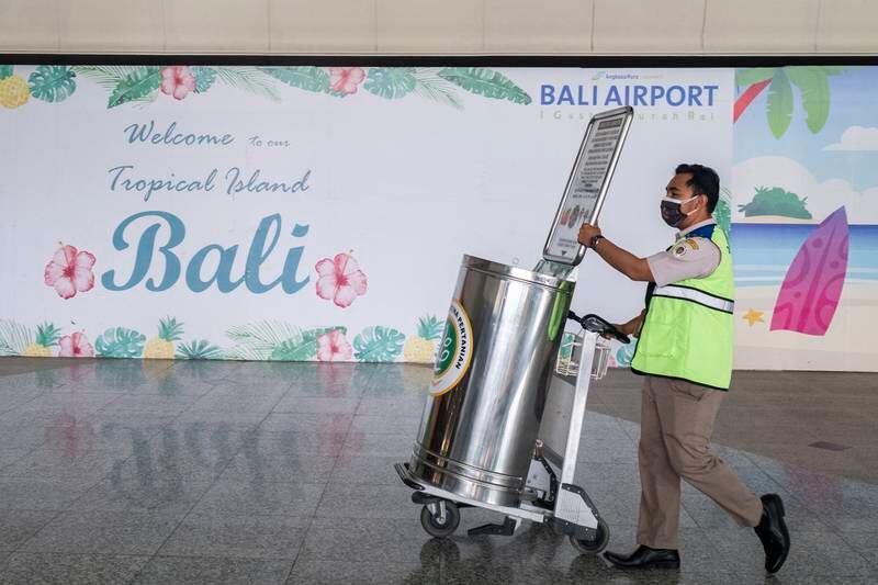 A quarantine officer at Bali's international airport. The holiday island is officially open to travellers from overseas again, but it's not quite so easy to travel there. EPA