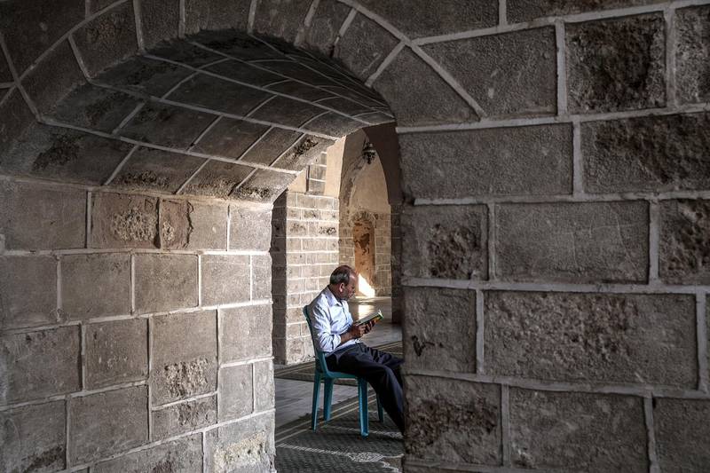 A Palestinian reads from the Quran at Al-Omari mosque in Gaza City.  EPA