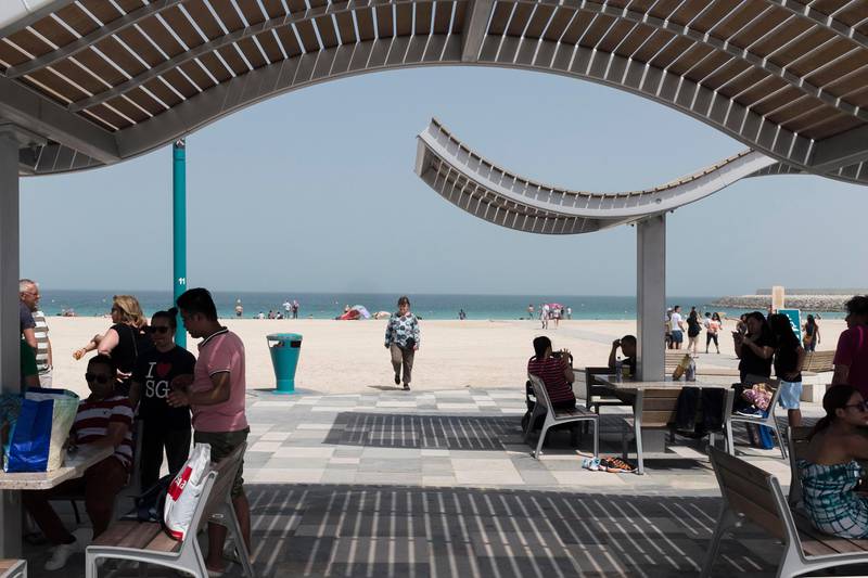 DUBAI, UNITED ARAB EMIRATES, 12 MAY 2017. STANDALONE. Enjoying the early morning sunshine on the commonly known Sunset beach next to the Burj Al Arab. A woman walks towards the shade while temperatures reach into the mid 30's. (Photo: Antonie Robertson/The National) ID: None. Journalist: None. Section: National. *** Local Caption ***  AR_1205_Standalone_Beach-03.JPG