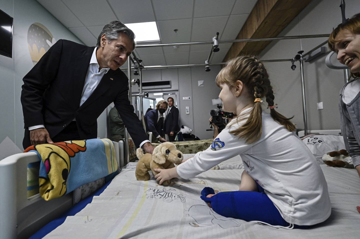 US Secretary of State Antony Blinken gives a gift to Marina, 6, from the Kherson region, during a visit to a children's hospital in Kyiv, Ukraine. AP
