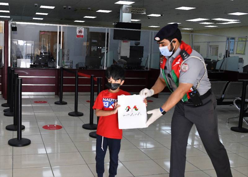 A boy from Oman gets a gift bag from an Abu Dhabi Police official.