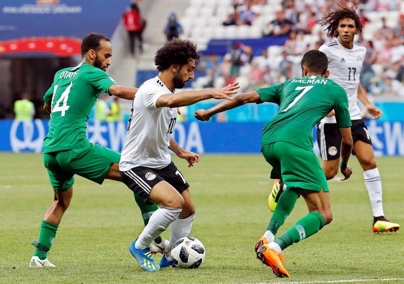 Mohamed Salah in action against Saudi players Abdullah Otayf, left, and Salman Al-Faraj, right, during their Group A match. EPA