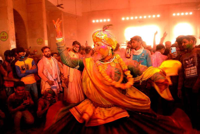 Hindu devotees dance as colored powder is thrown on them at Ladali, or Radha temple, at the legendary hometown of Radha, consort of Hindu God Krishna, during Lathmar holi, in Barsana, 115 kilometers (71 miles) from New Delhi, India, Tuesday, March 23, 2021. During Lathmar Holi the women of Barsana beat men from Nandgaon, the hometown of Krishna, with wooden poles in response to their teasing. (AP Photo)