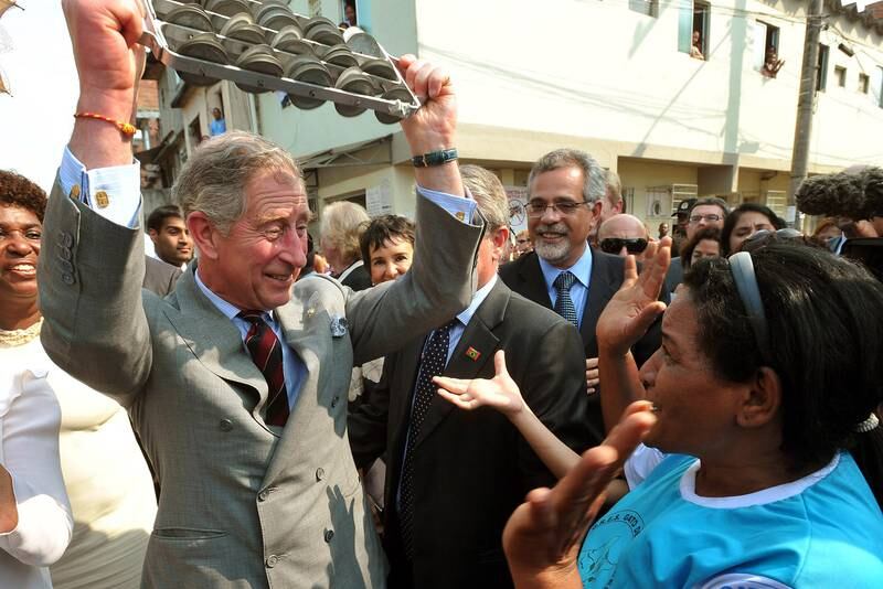 Prince Charles joins samba dancers as they perform during his tour of the Marie Complexo Favela in 2009 in Rio de Janeiro, Brazil.