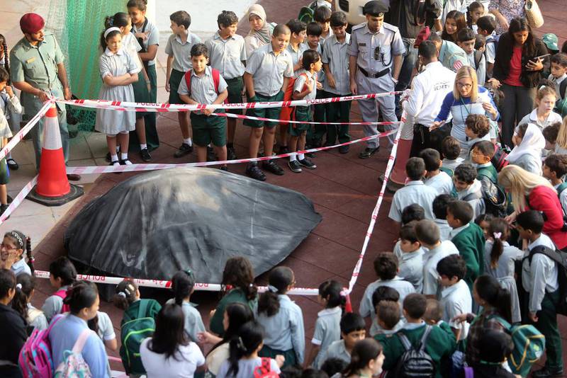 Children at Al Mushrif Primary School inspect a suspected UFO that landed at the school. Sammy Dallal / The National