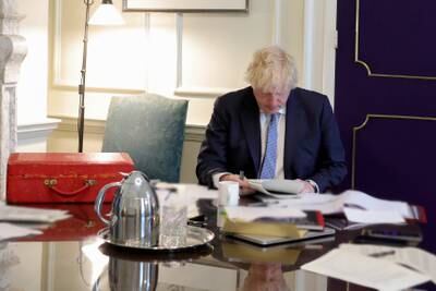 Mr Johnson reads the long-awaited report by senior civil servant Sue Gray into the Downing Street party scandal, in his Downing Street office in May 2022. Photo: Downing Street
