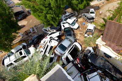 Cars that were washed away by heavy rains are piled up in an alley in the Saudi coastal city of Jeddah on November 25. AFP

