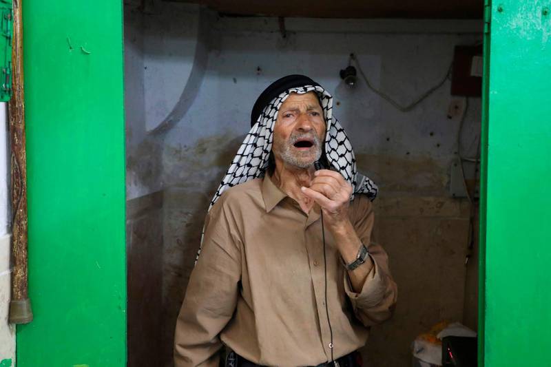 An elderly man calls for prayer and Palestinians gather for the last Friday prayer of the month of Ramadan inside the al-Sunyieh mosque in the old city of the occupied West Bank town of Hebron. AFP
