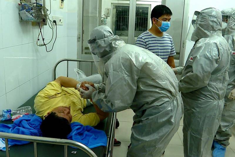 Officials from Vietnam's Ministry of Health talk to a man tested positive for the Wuhan coronavirus, at an isolated section at Cho Ray hospital, in Ho Chi Minh city, Vietnam. EPA